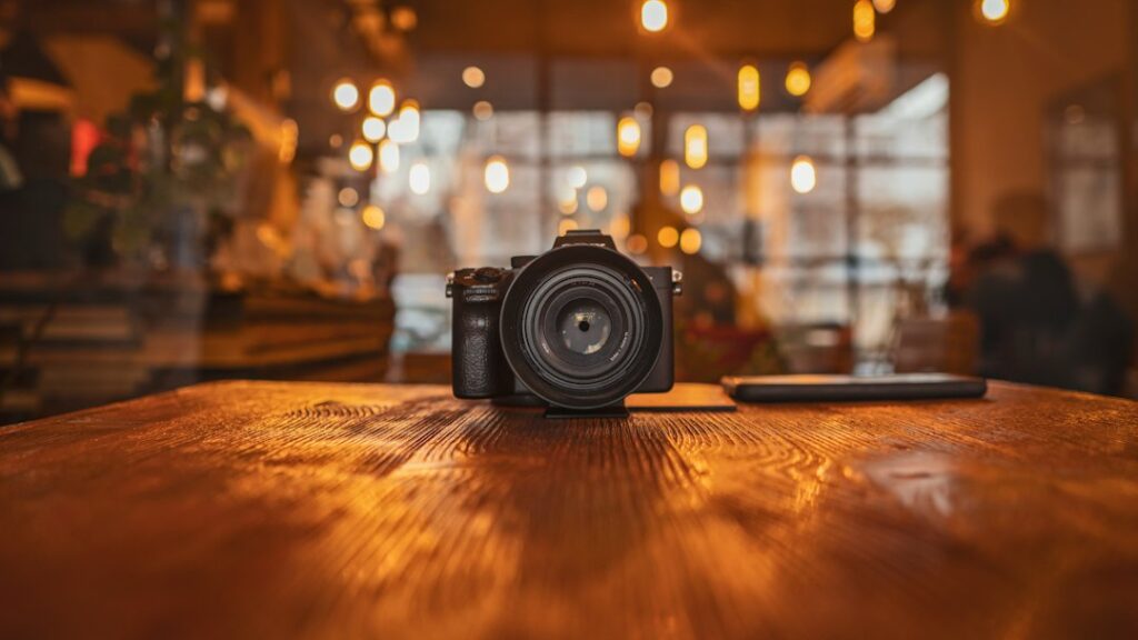 DSLR camera on wooden table in cozy cafe.