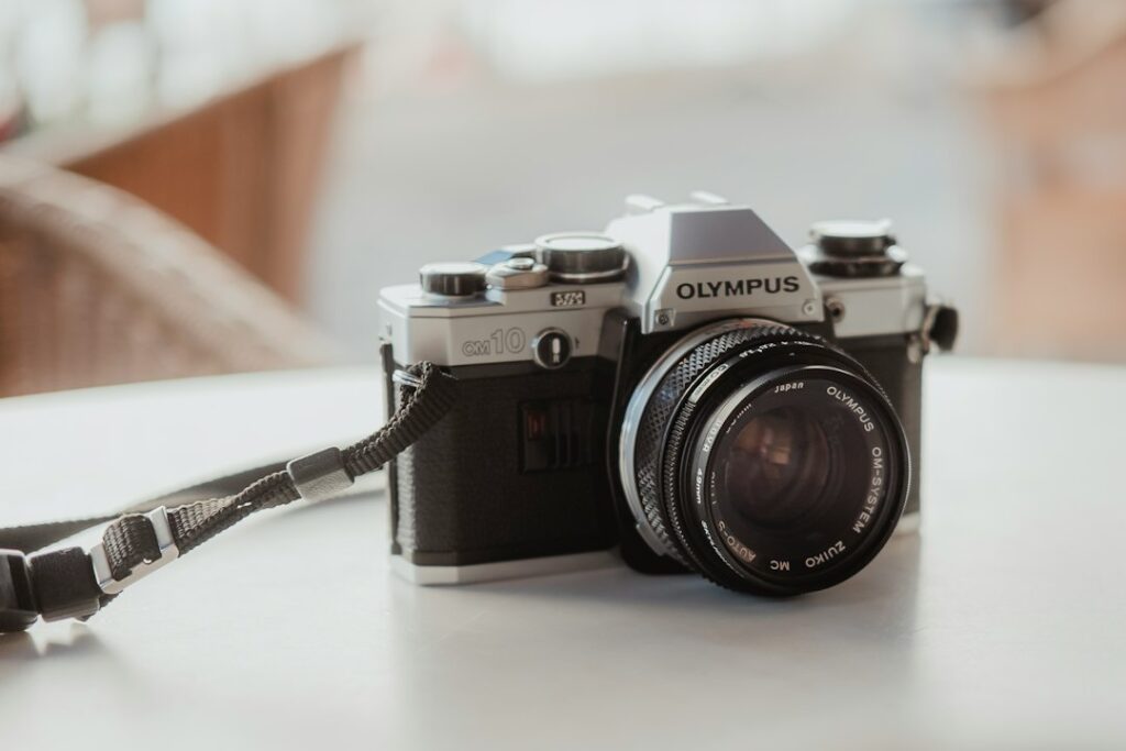 Olympus OM-10 film camera on table.