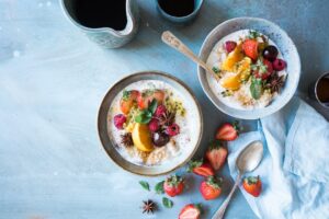 Fresh fruit oatmeal bowls on blue background.