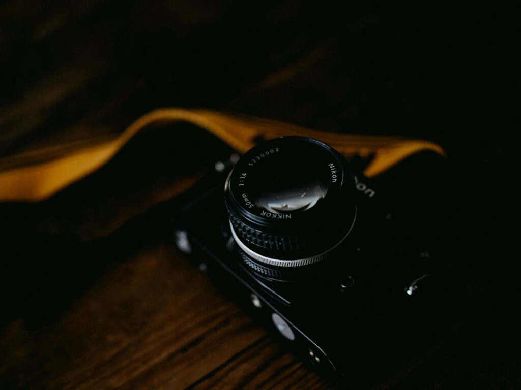 Vintage camera with lens on wooden surface.