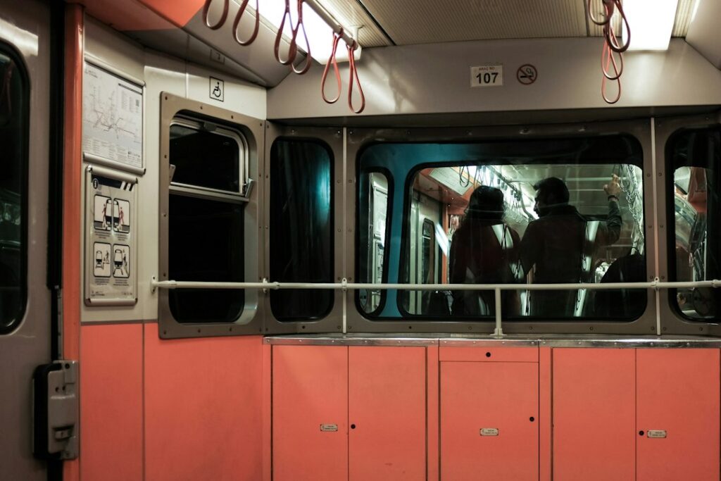 Passengers inside a subway train at night.