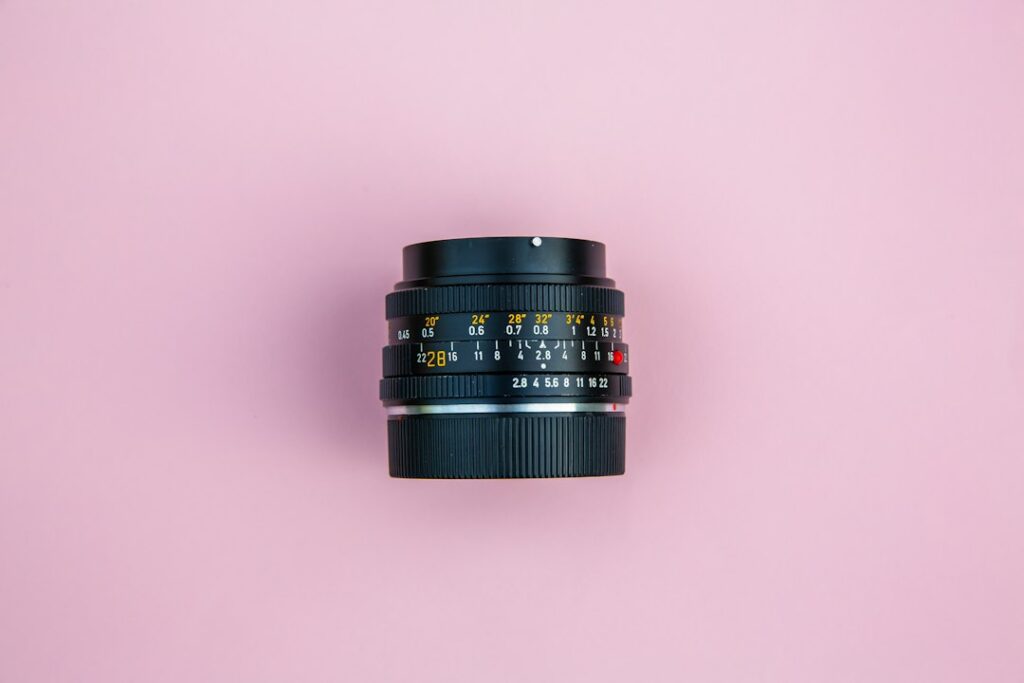 Camera lens on pink background.