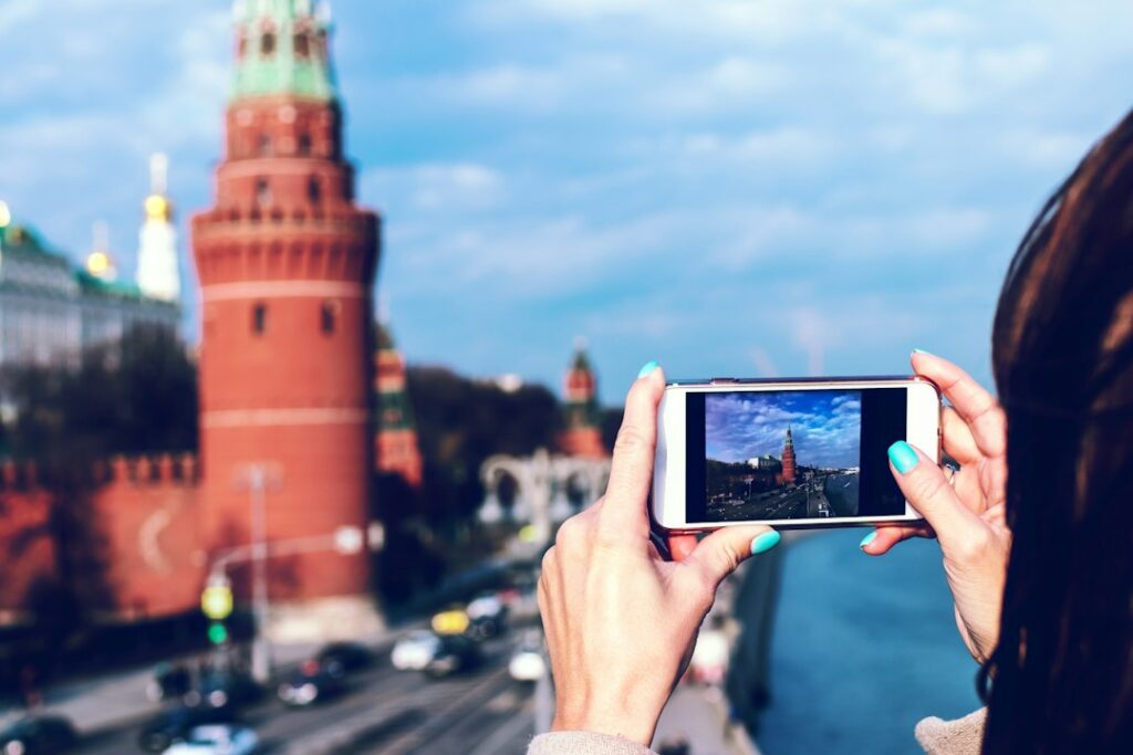Person capturing Kremlin view on smartphone camera.