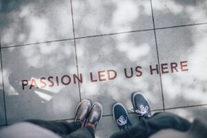 Inspirational sidewalk quote with people's feet beside it.