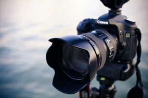 Canon DSLR camera on tripod by water.