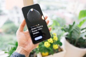 Hand holding smartphone displaying digital payment app.