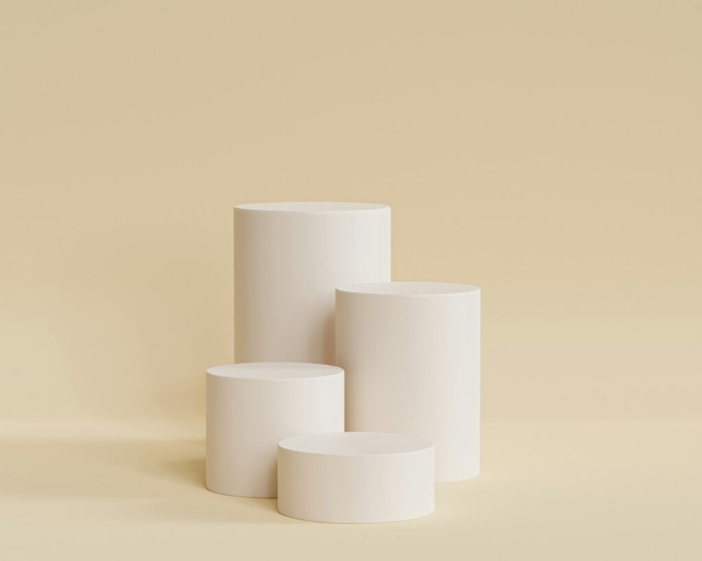 Simple white cylindrical pedestals on beige background.