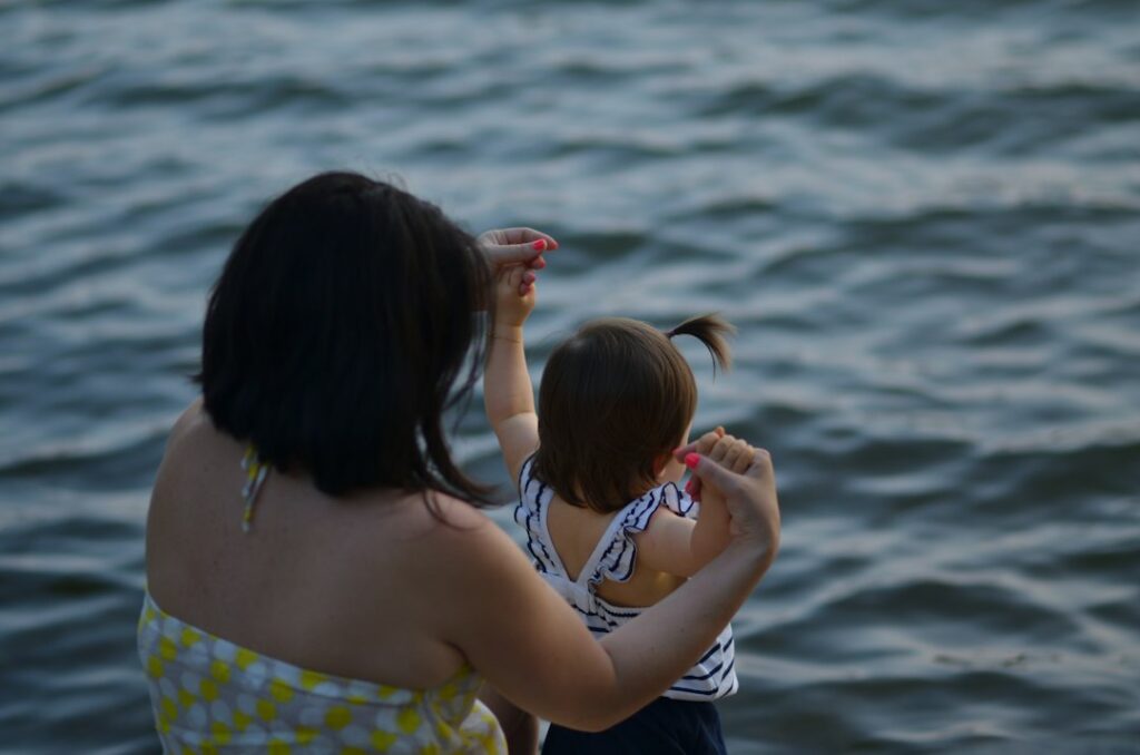 Woman and child pointing over water
