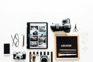 Creative work essentials flat lay with camera and tablet.