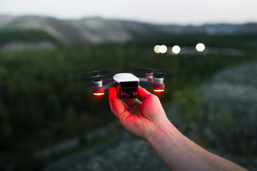 Hand launching drone outdoors at dusk.