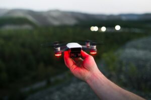 Hand launching drone outdoors at dusk.