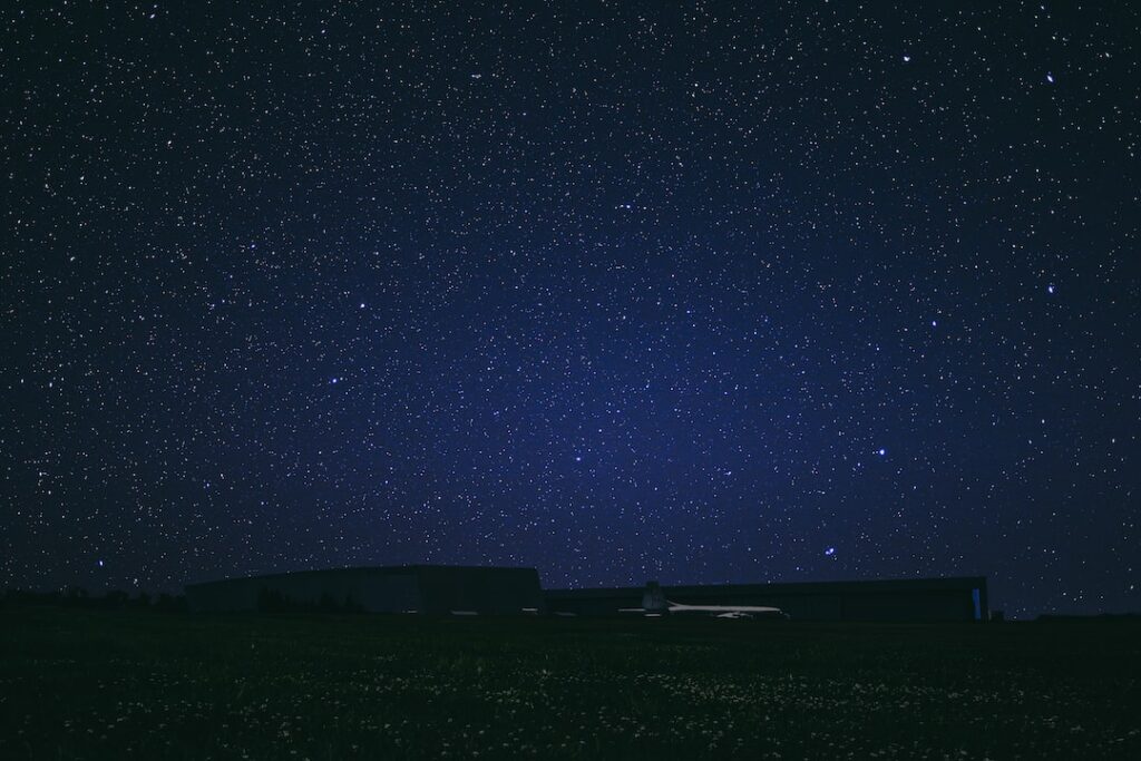 Star-filled night sky over rural airport.