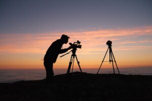 Silhouette of photographer with tripods at sunset.