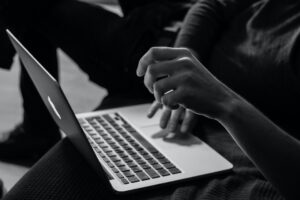 Person working on laptop in grayscale