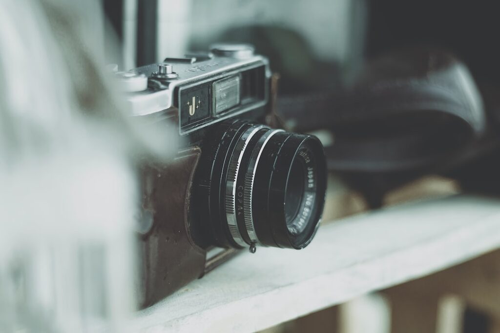 Vintage camera on wooden shelf.