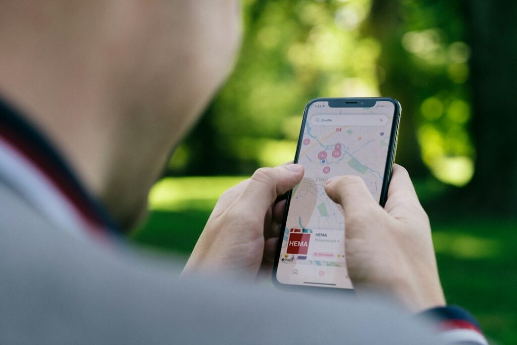Person using smartphone map app outdoors.