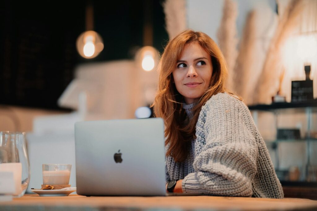 Woman working on laptop in cozy cafe setting